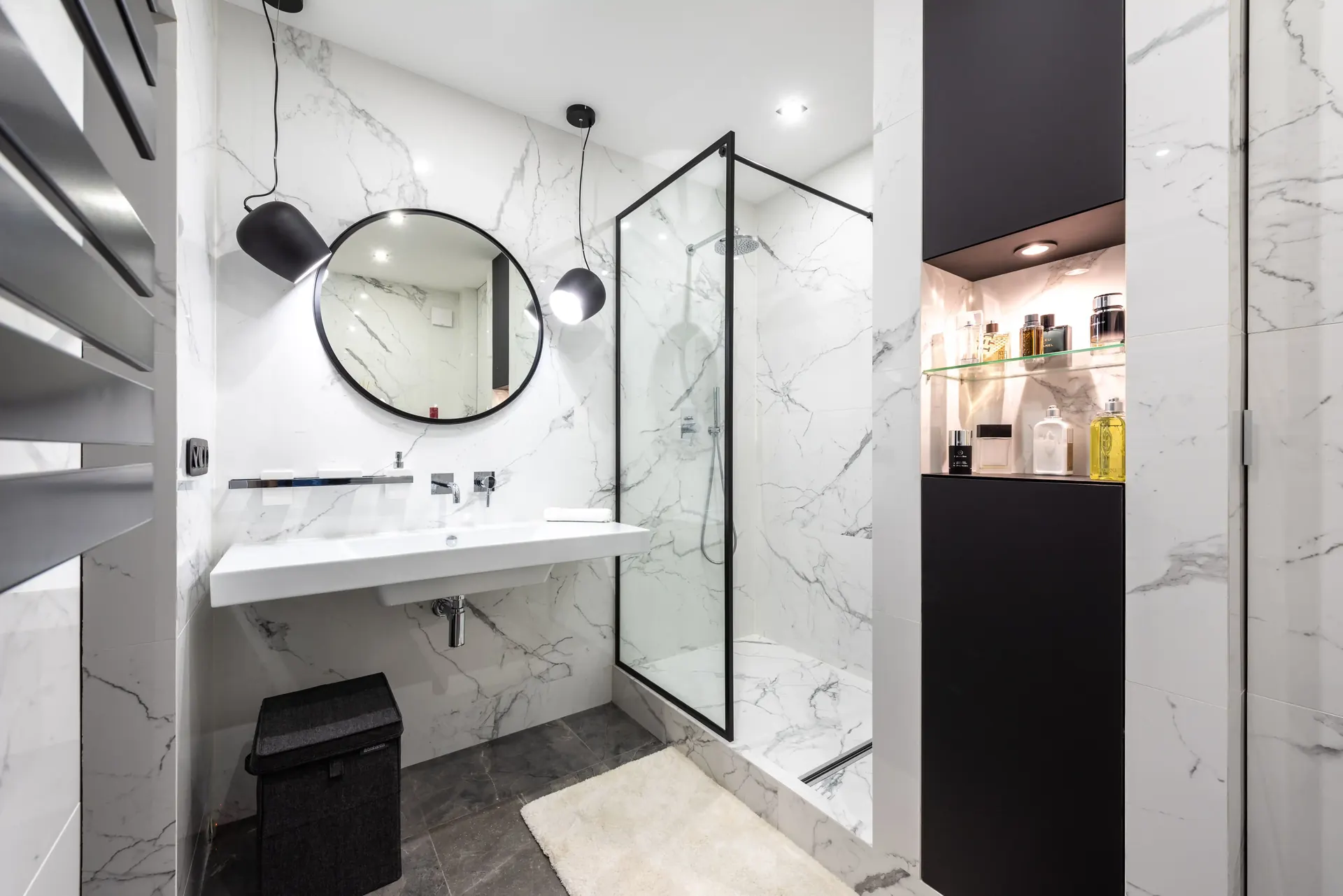 Modern bathroom with white marble-look tile and a glass shower