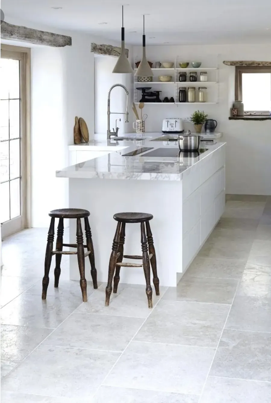 Light stone-look tile floor in a kitchen with an island