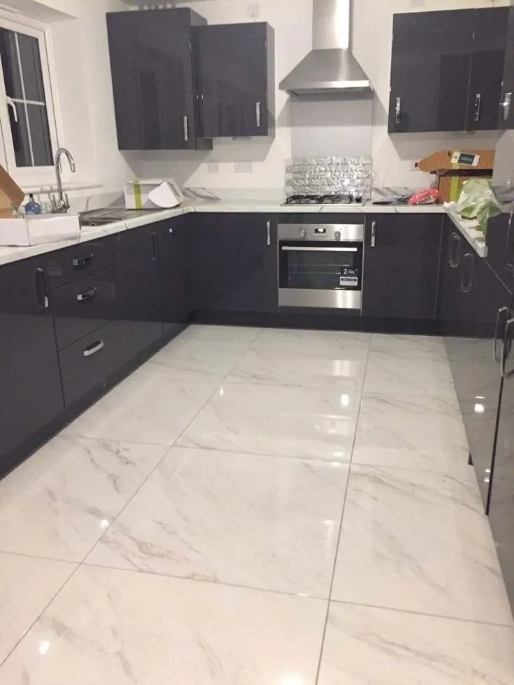 Kitchen with large marble-look porcelain floor tile and dark cabinets